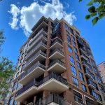 senthi2034_modern_condo_buildings_looking_upwards_blue_sky